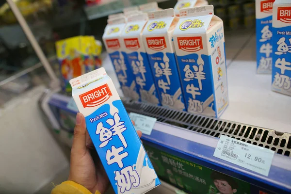 顧客は 中国の上海のスーパーマーケットでブライトフードグループのブライト食品グループのカートンを購入します 12月 2012 — ストック写真