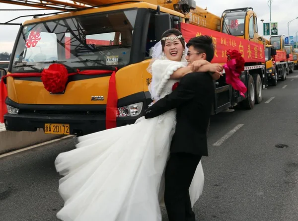 Китайский Жених Цзянцзянь Обнимает Свою Невесту Перед Кортежем Крановых Грузовиков — стоковое фото