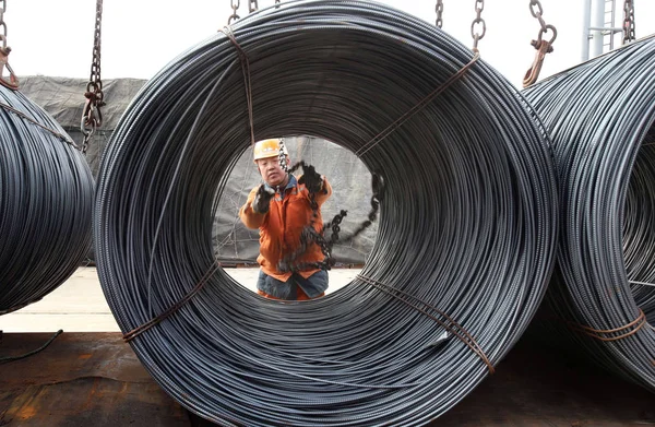 2015年12月9日 在中国东部江苏省连云港市 一名中国工人用铁棍盘绕钢条从卡车上卸下 — 图库照片