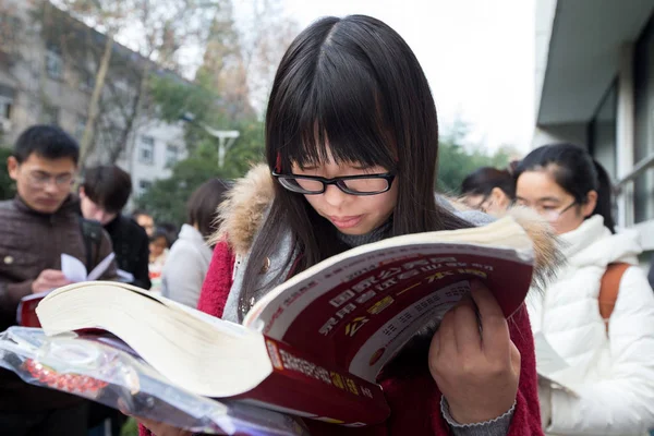 2015年11月29日 中国考生在南京林业大学参加国家公务员考试前复习教材 — 图库照片