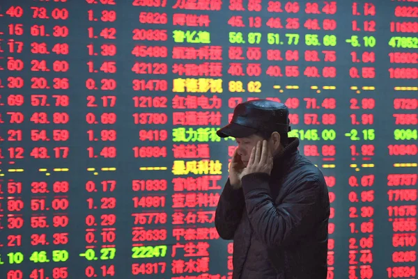 中国の株式投資家は 2015年12月14日 中国東部の浙江省杭州市の株式仲介会社で 株価を表示する画面を見る 価格上昇の赤と価格下落のための緑 — ストック写真