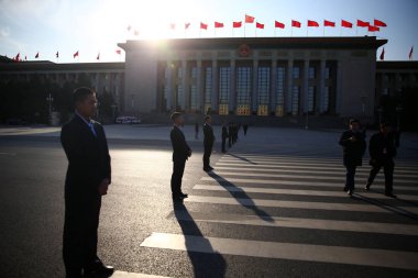 Security staff stand guard on a road near the Great Hall of the People during the fourth plenary meeting of the third session of the 12th National Committee of the CPPCC (Chinese People's Political Consultative Conference) in Beijing, China, 11 March clipart