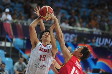 A player of Malaysia, right, challenges Joji Takeuchi of Japan in a group match during the 2015 FIBA Asia Champions for Men in Changsha city, central China's Hubei province, 24 September 2015