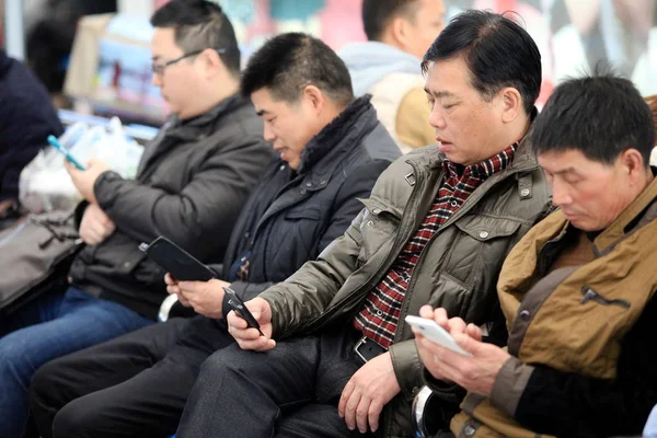 Los Pasajeros Chinos Usan Sus Teléfonos Móviles Mientras Esperan Trenes — Foto de Stock
