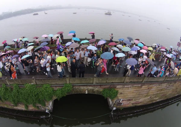 Turisti Che Tengono Ombrelli Piedi Attraverso Ponte Rotto Sul Lago — Foto Stock