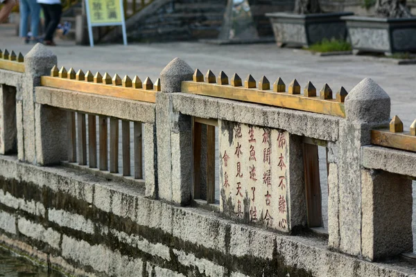 中国南東部福建省アモイ市の南普陀寺のプールの周りのガードレールに木製の釘が設置されています — ストック写真