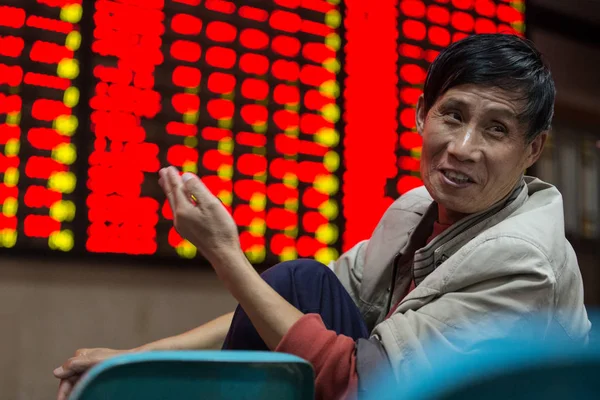 Китайский Инвестор Улыбается Указывая Экран Показывающий Цены Акции Красный Роста — стоковое фото
