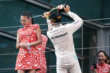 Britain's Lewis Hamilton of Mercedes, right, sprays champagne on the face of a hostess during the award ceremony of the 2015 Formula 1 Chinese Grand Prix at the Shanghai International Circuit in Shanghai, China, 12 April 2015. clipart