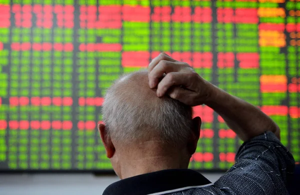 2015 日中国東部の浙江省杭州市の証券会社の家で 赤の価格上昇 と価格下落のため緑の株式の価格を見て懸念している中国語の投資家 — ストック写真
