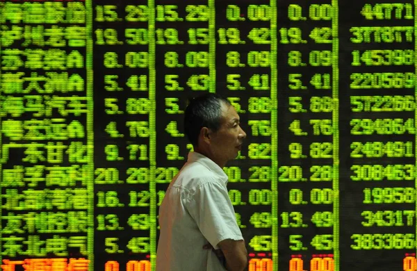 2015年8月25日 在中国东部江西省九江市一家股票经纪公司 一位关心此事的中国投资者走过显示股价 绿色价格下跌 的屏幕 — 图库照片