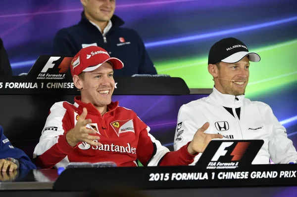 车手法拉利的塞巴斯蒂安 维特尔 和英国 车手马拉伦的简森 巴顿出席了2015年4月9日在中国上海国际赛车场举行的2015年一级方程式中国大奖赛新闻发布会 — 图库照片