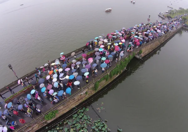 Turisti Che Tengono Ombrelli Piedi Attraverso Ponte Rotto Sul Lago — Foto Stock