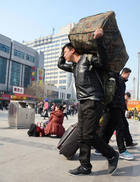 2015年2月13日 一名中国乘客在向中国中部河南省郑州火车站走去时 带着行李回家 — 图库照片