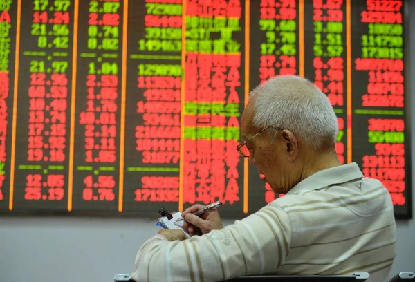 2015年5月19日 中国东部浙江省杭州一家股票经纪公司的股价 价格上涨为红色 价格下跌为绿色 一位中国投资者做了笔记 — 图库照片
