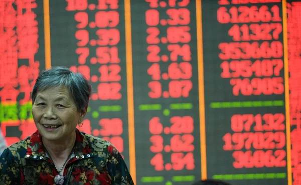 Китайський Інвестора Посміхається Перед Екраном Відображення Цін Акцій Червоний Зростання — стокове фото
