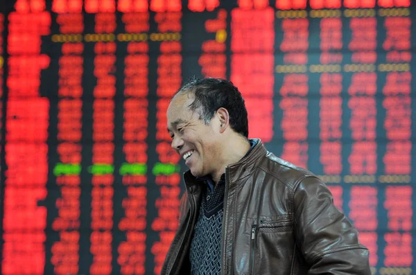 Китайський Інвестора Посмішки Перед Дисплеєм Показуючи Цін Акцій Червоний Зростання — стокове фото