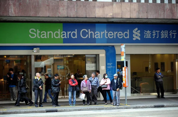 2015年1月8日 旅客在渣打银行香港分行前的汽车站等候 — 图库照片
