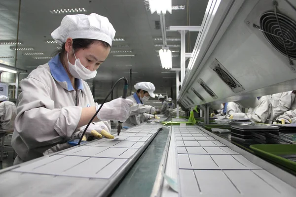 中国の労働者は 2013年7月29日 中国東部江蘇省梁陽市の上海深州新エネルギー開発有しの工場で ヨーロッパに輸出されるソーラーパネルを組み立てます — ストック写真
