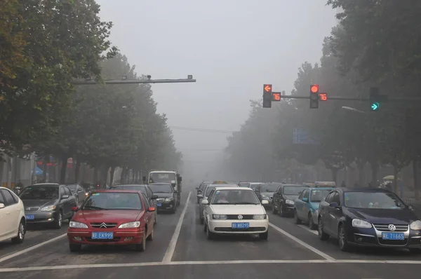 2013年11月3日 中国北部河北省新台市の重いスモッグの道路で 車が緑色のライトを待つために止まる — ストック写真