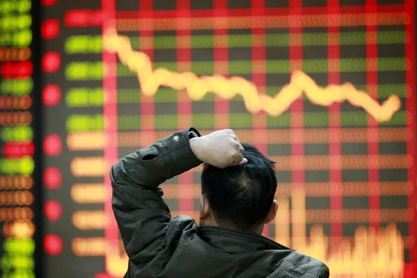 2015 日中国東部の安徽省淮北区内証券家で株価指数を見て懸念している中国語の投資家 — ストック写真