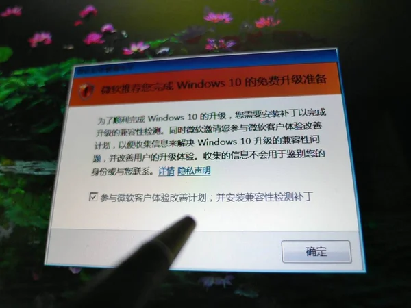 中国のネチゼンは 2015年7月24日 中国中部の湖北省のYichang市にあるラップトップコンピュータ上で マイクロソフトのWindows 10オペレーティングシステムをアップグレードするメッセージを見ています — ストック写真