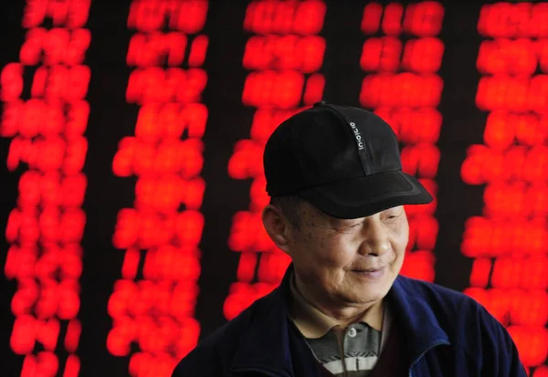 Китайський Інвестора Посміхається Перед Екраном Відображення Цін Акцій Червоний Зростання — стокове фото
