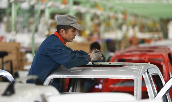 中国人労働者は 2014年12月16日 中国東部山東省ゾーピング郡の自動車工場で組み立てラインに車を組み立てます — ストック写真