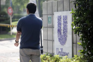 A pedestrian walks past the Shanghai Research and Development Center of Unilever in Shanghai, China, 15 May 2014.  clipart