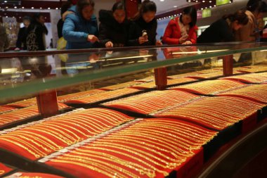Chinese customers buy gold ornaments at a jewelry store in Xuchang city, central Chinas Henan province, 8 December 2013.  clipart