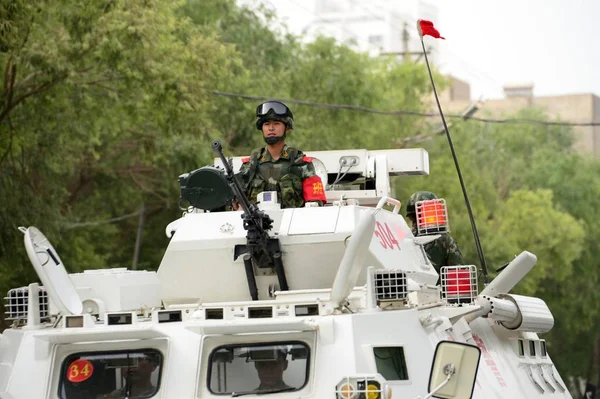 Uzbrojony Chiński Policjant Paramilitarny Stoi Pojeździe Patrolowym Podczas Patrolu Miejskiego — Zdjęcie stockowe