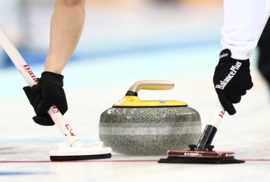 Tetsuro Shimizu, left, and Tsuyoshi Yamaguchi of Japan sweep against Switzerland in their eighth session of the round robin during the World Mens Curling Championship 2014 in Beijing, China, 31 March 2014 clipart