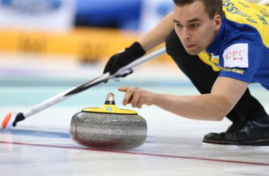 Oskar Eriksson of Sweden releases a stone against Switzerland in their thirteenth session of the round robin during the World Mens Curling Championship 2014 in Beijing, China, 2 April 2014 clipart