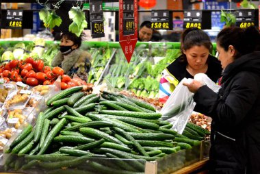 Chinese customers shop for vegetables at a supermarket in Qiqihar city, northeast Chinas Heilongjiang province, 9 March 2014 clipart