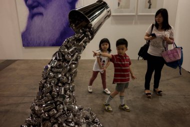 Visitors look at the artwork, Ray, by Indian artist Subodh Gupta, during the second edition of Hong Kongs Art Basel fair at the Hong Kong Convention & Exhibition Centre (HKCEC) in Hong Kong, China, 17 May 2014 clipart