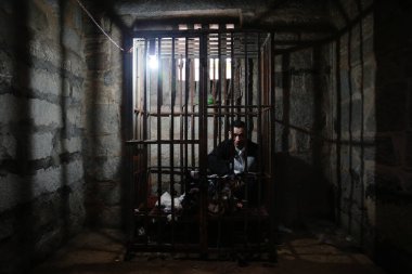 Mentally-disturbed man Hong Zhengqu sits in a cage at home in Baisha Village, Dongshi Town, Jinjiang city, southeast Chinas Fujian province, 18 February 2014 clipart