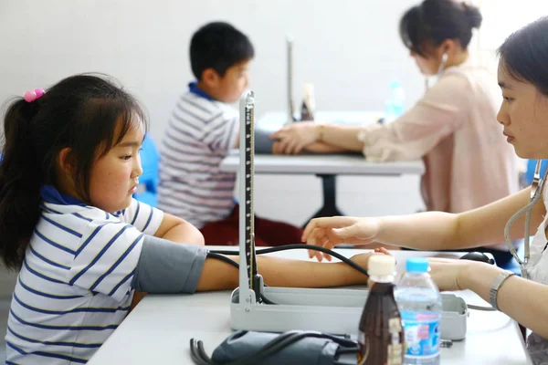 Chińscy Pracownicy Mierzą Ciśnienie Krwi Otyłych Młodych Studentów Podczas Badania — Zdjęcie stockowe
