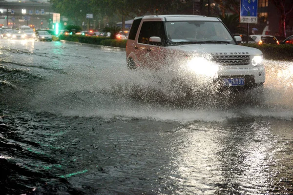 Ένα Λαντ Ρόβερ Suv Τρέχει Ένα Πλημμυρισμένο Δρόμο Που Προκαλείται — Φωτογραφία Αρχείου