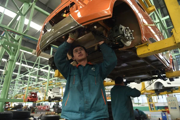中国の労働者は 2014年12月16日 中国東部山東省ゾーピング郡の自動車工場で組み立てラインに車を組み立てます — ストック写真