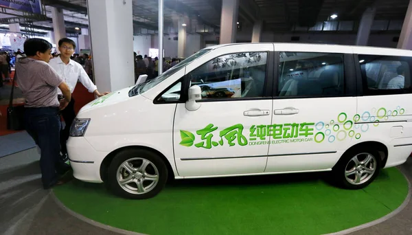 2013년 베이징에서 전시회에서 직원이 둥펑의 전기자동차를 방문객에게 소개하고 — 스톡 사진