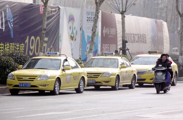 2015年1月10日 在中国东部江苏省南京市 骑自行车经过停在公路上的出租车 而他们的司机则举行罢工 — 图库照片