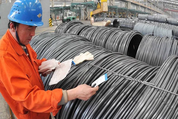 2014年4月16日 中国工人在辽宁省大连市东北特殊钢集团工厂检查卷绕钢棒 — 图库照片