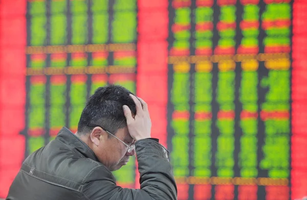 2015 日中国東部の安徽省阜陽市の株式 Broekrage 赤の価格上昇 と価格下落のため緑の株式の価格を見て懸念している中国語の投資家 — ストック写真