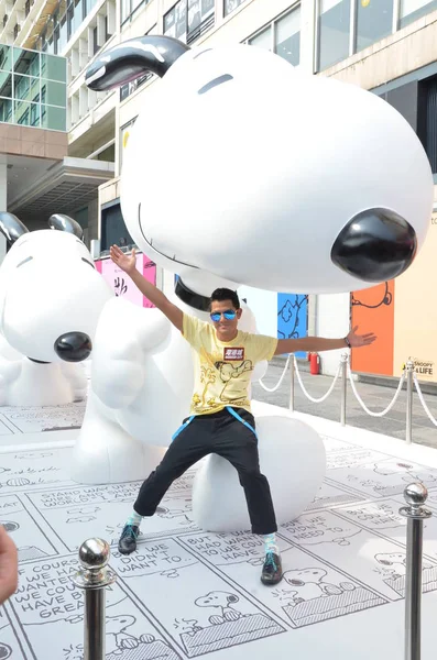香港の歌手 俳優アーロンクォック香港 2014 日チャリティー イベントの間にスヌーピー像ポーズします — ストック写真