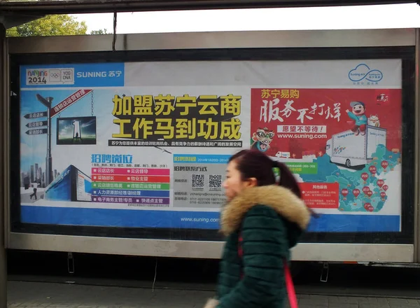 2014년 16일 후베이성 이창시의 Suning Group 광고를 지나걷는 보행자 — 스톡 사진