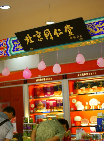2013年8月11日 顾客在北京同仁堂公司 自1669年以来的中药药房 的分店购物 — 图库照片