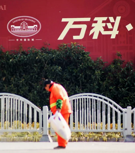 2013年3月3日 中国万科的广告前 一位中国清洁工清理垃圾 — 图库照片