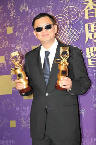 香港导演王家卫2014年3月5日在中国香港举行的香港电影导演公会颁奖典礼上 与他的最佳导演及最佳电影奖杯合影 — 图库照片