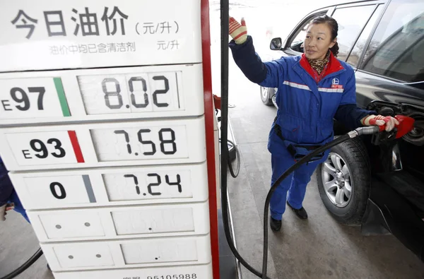 2014年1月11日 中国东部安徽省淮北市中石化加油站 一名员工在价格板旁加油 — 图库照片