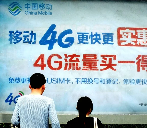 歩行者は 中国中央部湖北省の中国モバイルの4G Lteネットワークの広告を見て 2014年3月30日 — ストック写真