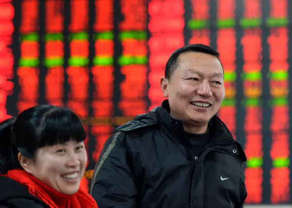 Китайські Інвестори Посміхаючись Перед Екраном Відображення Цін Акцій Червоний Зростання — стокове фото